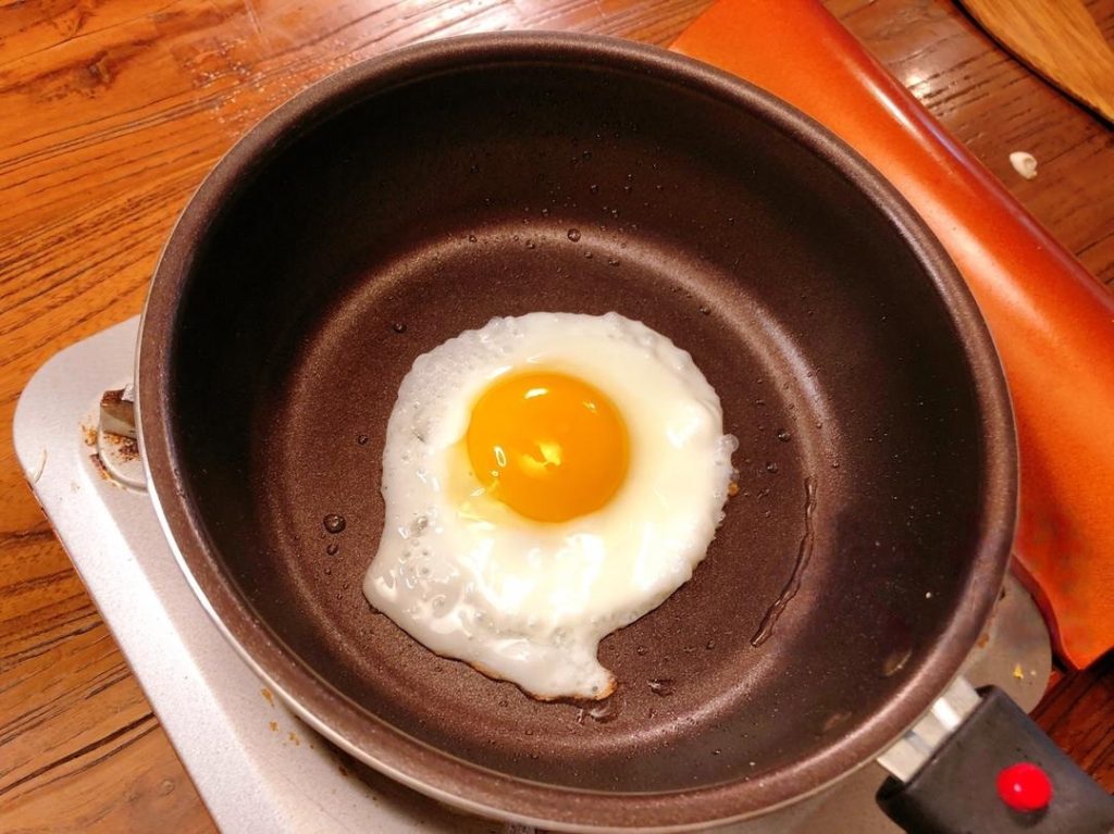 Heat a little oil in a pan. Crack an egg in gently.