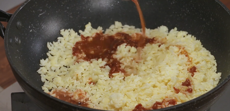 Once the rice is dry and fluffy, pour the soybean paste slurry over the rice.