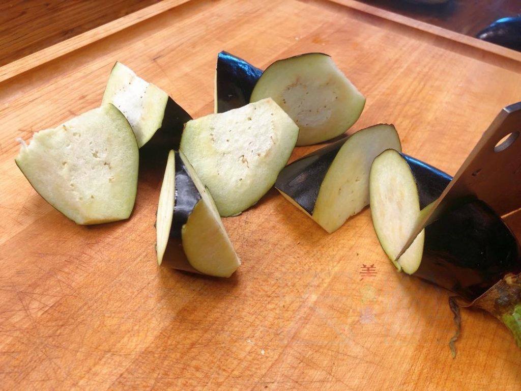 Wash the eggplant. Do not peel (unless using thick-skinned globe eggplant). Cut into large rolling wedges.