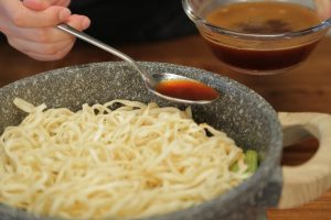 Steam-Braise (The "Men" Process): Turn the heat to low. Let it steam for about 5 minutes. Uncover and drizzle half of the reserved soup along the edge of the wok (not directly on the noodles if you can avoid it, to keep them chewy). Cover and cook for another 5 minutes. Repeat with the remaining soup.