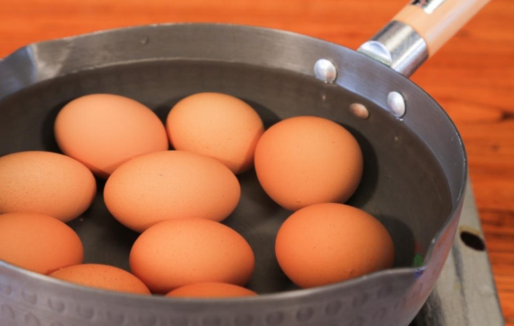 The Initial Boil Place the washed eggs in a pot and add enough cold water to cover them by an inch. Turn the heat to medium. Once the water reaches a boil, set a timer and cook for 10 minutes.