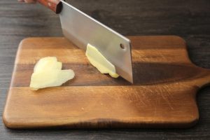 Start by preparing your aromatics. Slice the ginger into 6 thick slices.