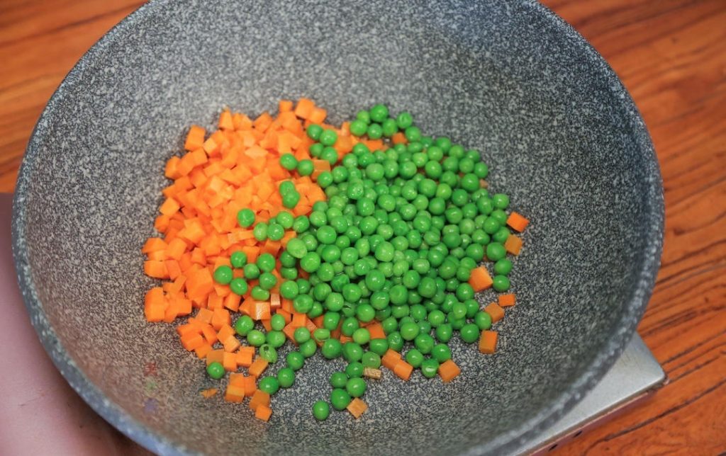 Sauté the Vegetables Heat your wok or skillet over medium heat. Add the oil. Once shimmering, add the diced carrots and the blanched peas. Stir-fry gently until the carrots slightly change color and soften (about 2 minutes).
