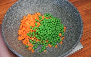 Sauté the Vegetables Heat your wok or skillet over medium heat. Add the oil. Once shimmering, add the diced carrots and the blanched peas. Stir-fry gently until the carrots slightly change color and soften (about 2 minutes).