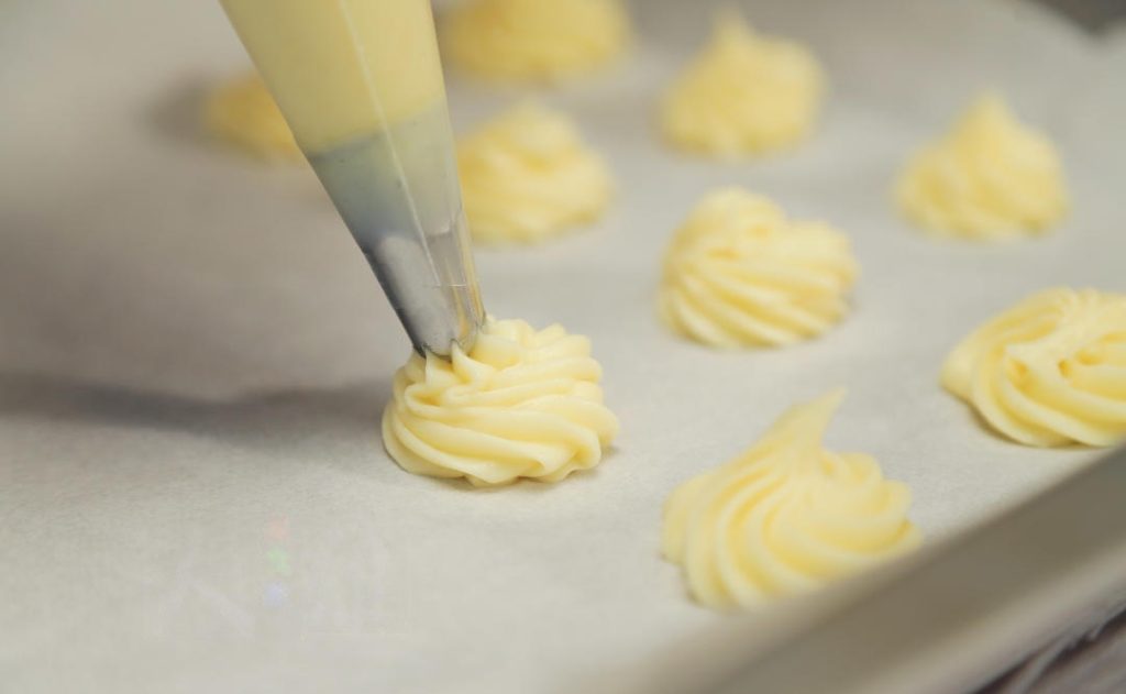 Pipe: Transfer the batter to a piping bag. Pipe rounds (about 1.5 to 2 inches wide) onto a parchment-lined baking sheet, leaving space between them. You can use a wet finger to pat down any pointy peaks.