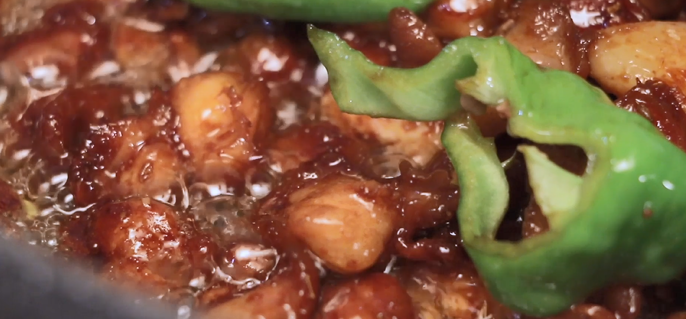 Toss in the cumin seeds, fennel seeds, sliced Long Green Peppers, and Thai chilies.