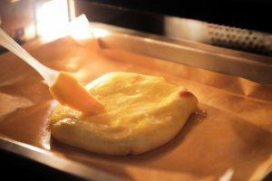 Remove the pies from the oven. Brush the top surface generously with the beaten egg yolk.