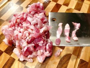 Cut the 250g (½ lb) of pork belly into small dice, about 1cm cubes (think "minced meat" but chunkier).