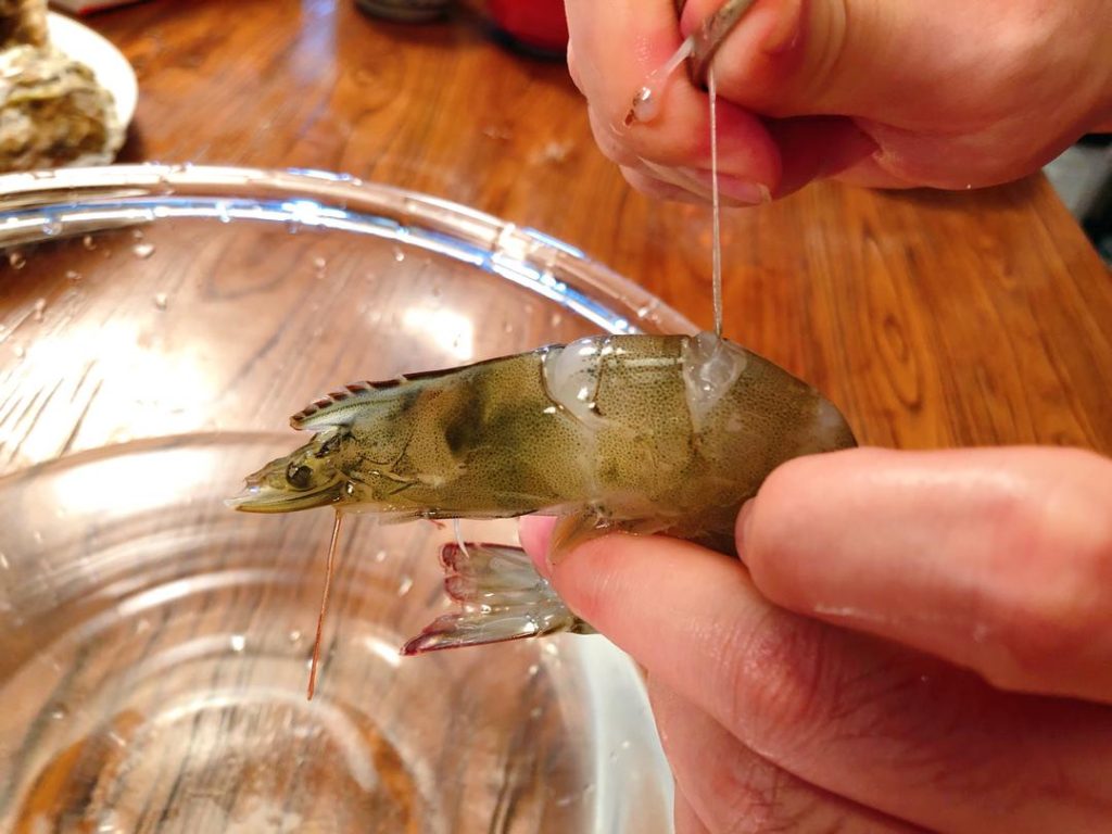 Shrimp: Place live shrimp in the freezer for 5 minutes to stun them (makes them easier to handle). Use scissors to snip the back and remove the dark vein (de-vein).
