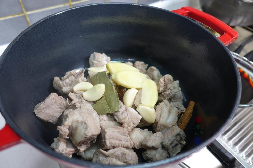 The Braise Place the blanched ribs into a clean stew pot or wok. Add the 6 slices of ginger, 5 cloves of garlic, 1 star anise, 1 bay leaf, and the small piece of cinnamon. Pour the pre-mixed sauce over the ribs. Add enough extra water to just barely cover the ribs.
