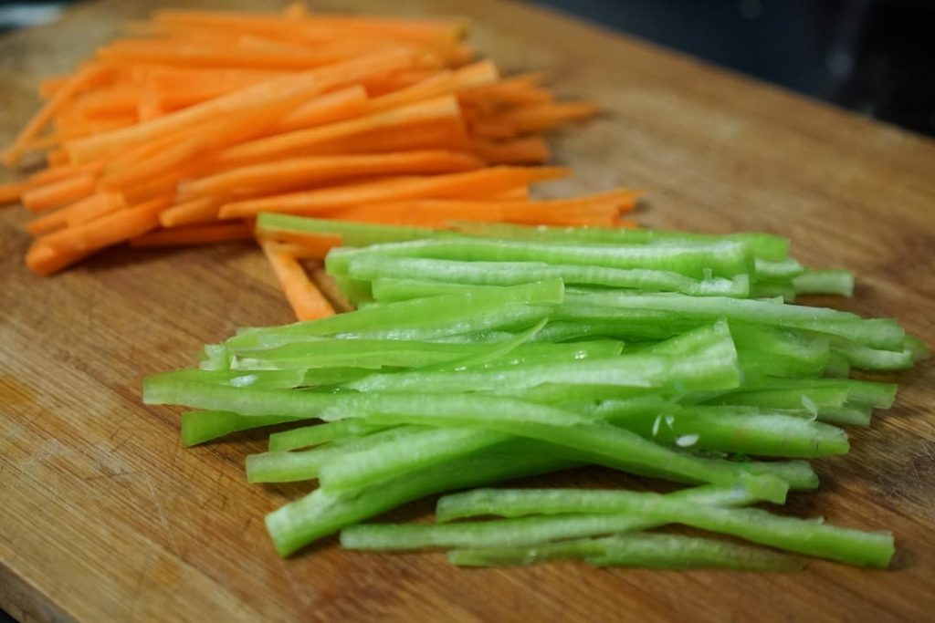Slice the carrot and green pepper into thin shreds (julienne).