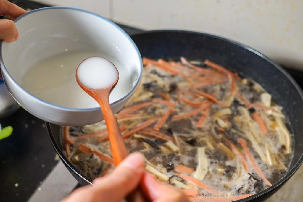 Give your cornstarch slurry a quick mix (starch settles at the bottom) and pour it into the boiling soup.