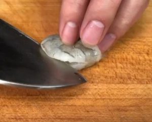 Peel and devein your shrimp. Using a sharp knife, slice along the back of the shrimp deeply, almost cutting it in half, but keeping the belly connected. This is deep butterflying.