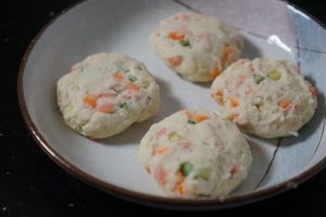Divide the dough into equal-sized balls (about the size of a golf ball). Press them gently between your palms to form small, round patties.