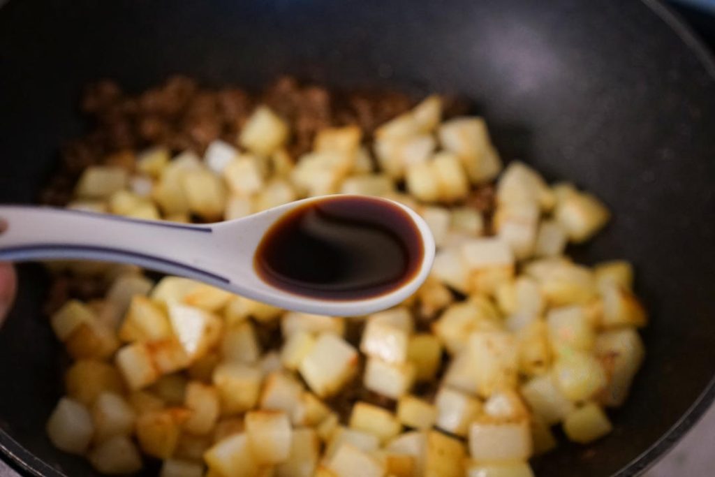 Pour in 2 tablespoons light soy sauce, 1 tablespoon oyster sauce, and ½ teaspoon sugar.