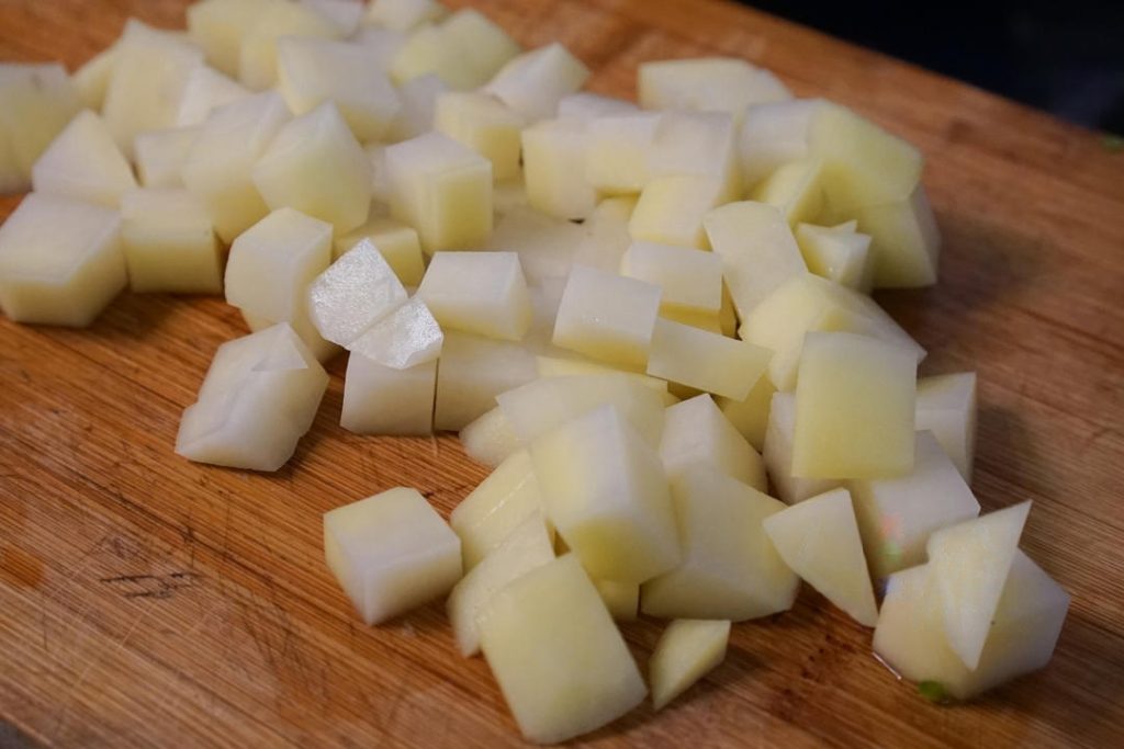 Wash and dice the celery and green peppers into small cubes. Peel the potatoes. First, slice the potatoes into thick slabs, then into strips, and finally into uniform cubes (about ½ inch or 1.5cm).