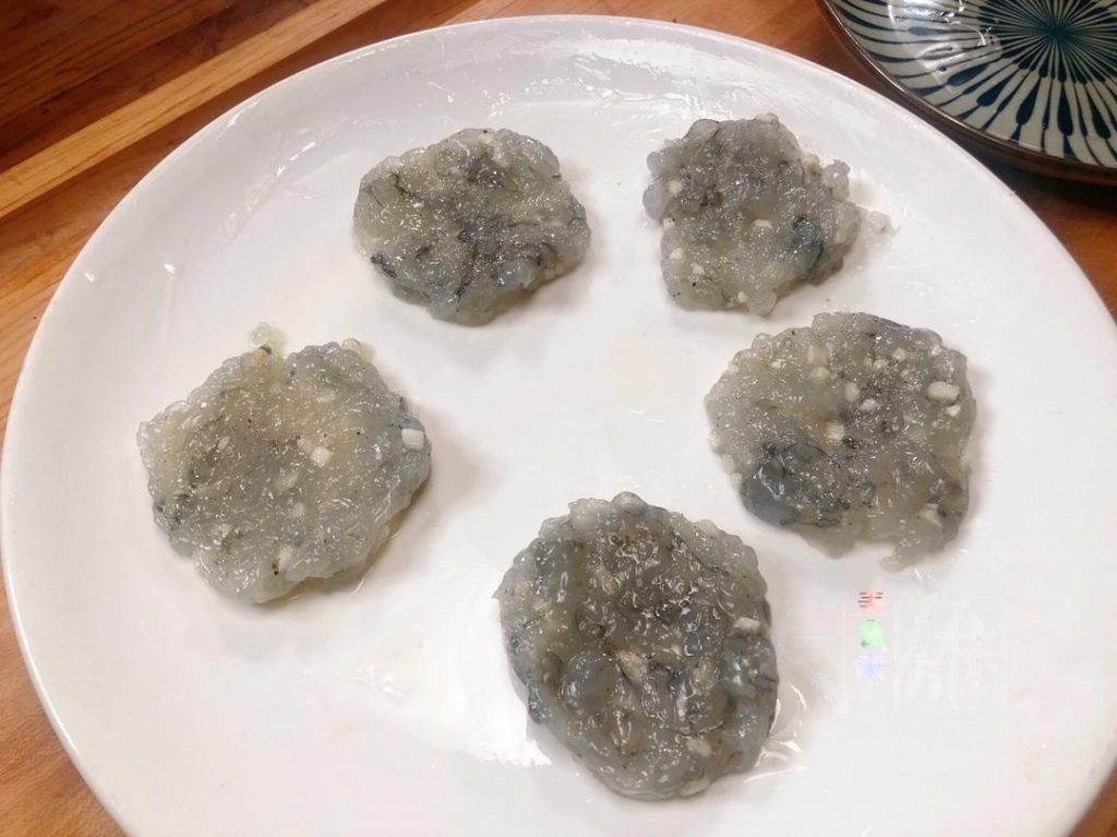 To get that perfect restaurant cylinder shape, you can use a round cookie cutter or a ring mold. Press the shrimp ball into the mold using a piece of carrot or cucumber dipped in oil to flatten it into a uniform cake.