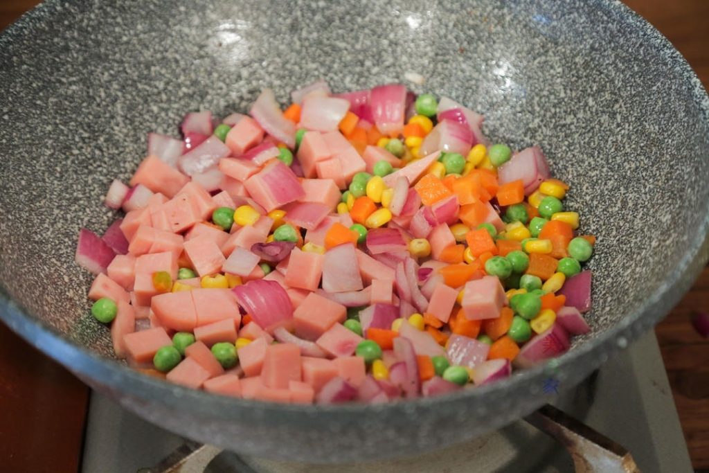 Add Vegetables: Toss in the mixed vegetable corn/peas/carrot mix and the diced ham. Stir-fry for 2 minutes until the vegetables are tender.