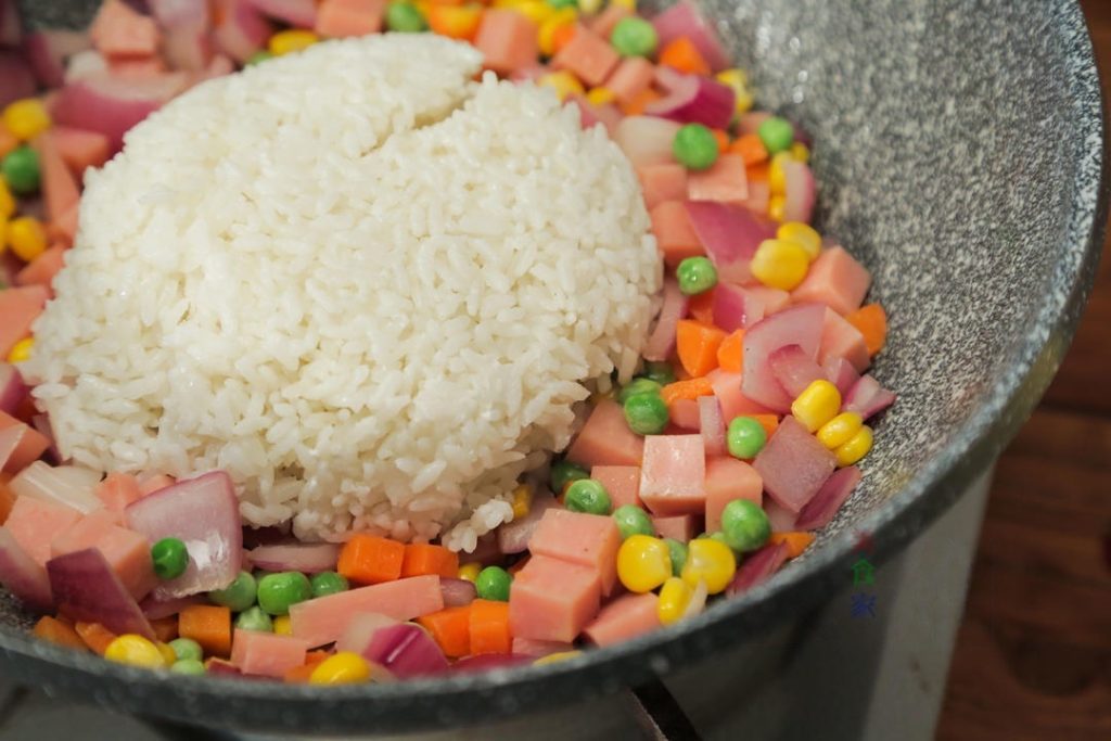 Fry the Rice: Add the cooked coconut rice to the wok. Use your spatula to break up any clumps.