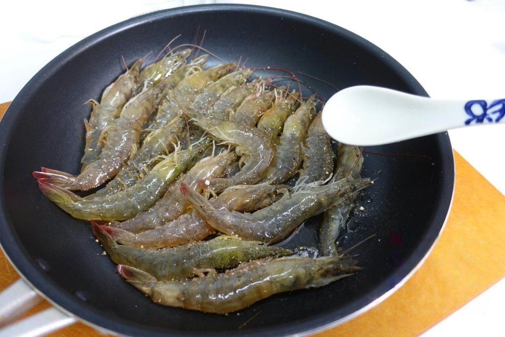 Season and Mix Add the salt and the generous amount of black pepper directly onto the shrimp in the pan.