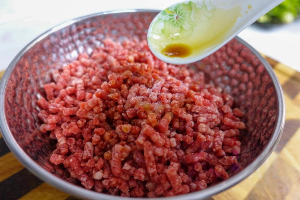 Place the ground beef in a bowl. Add 1 tablespoon Shaoxing Wine, 1 tablespoon Soy Sauce, and ⅓ teaspoon salt.