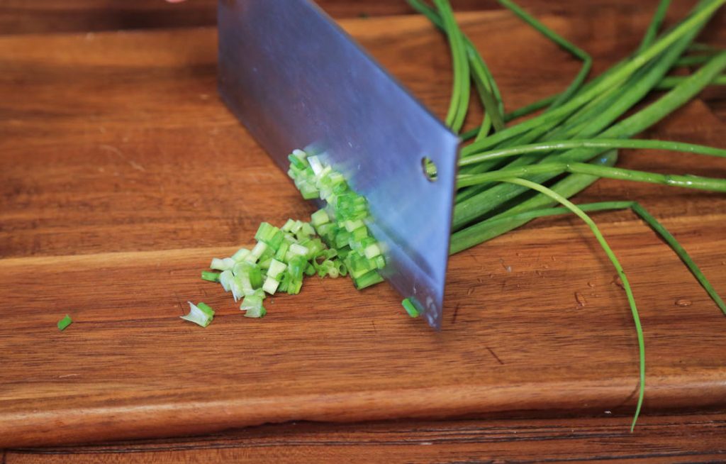 Aromatics: Mince the garlic and chop the scallions. Place them in your serving bowl along with the chili powder and sesame seeds.