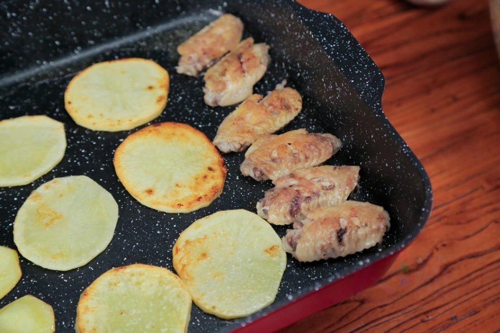 Pan-Fry for Texture: Heat about 2 tablespoons of oil in your wok or pot over medium heat. Add the chicken wings and potato slices. Pan-fry them until both sides are golden brown and the potato edges are slightly crispy. Remove and set aside.