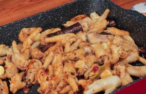 Combine and Season: Add the blanched chicken feet and wings back into the pot. Stir-fry to coat them in the red oil. Add the Light Soy Sauce and Oyster Sauce. Stir well to combine.