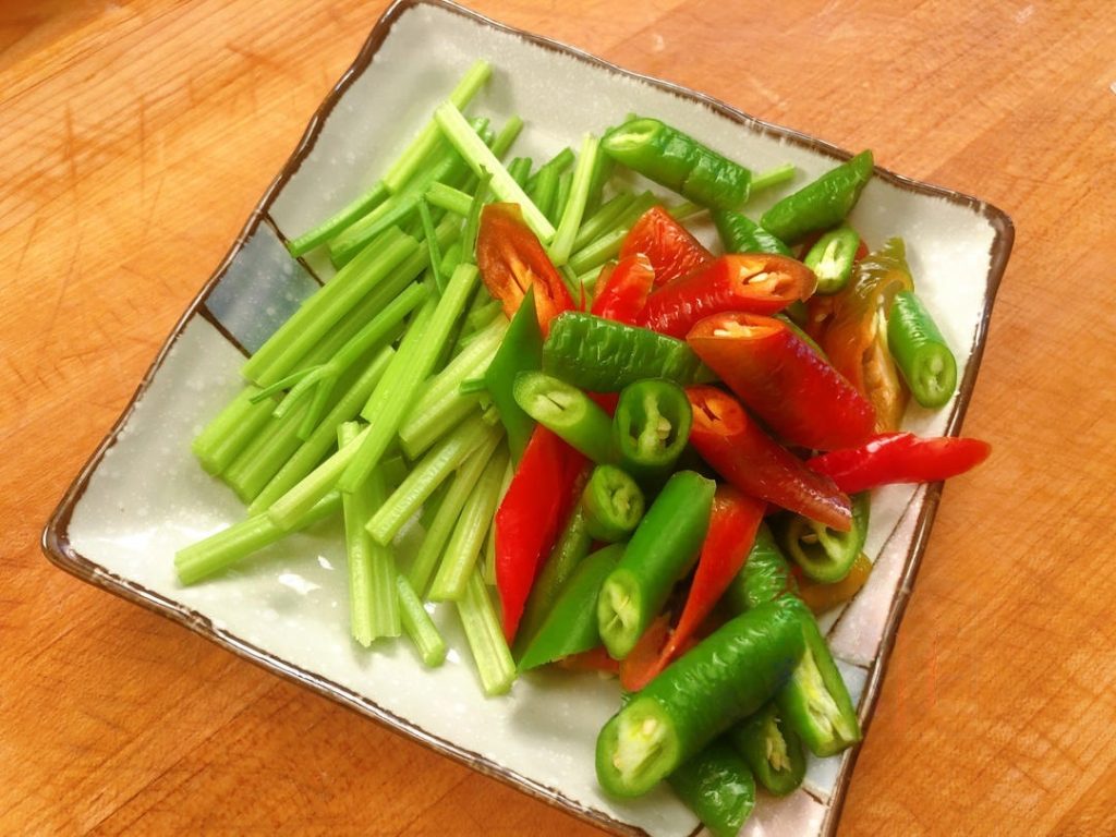 Cut the chili peppers into small segments (about 1 inch long). Cut the celery into similar-sized segments. Peel the garlic and slice it into thin chips.