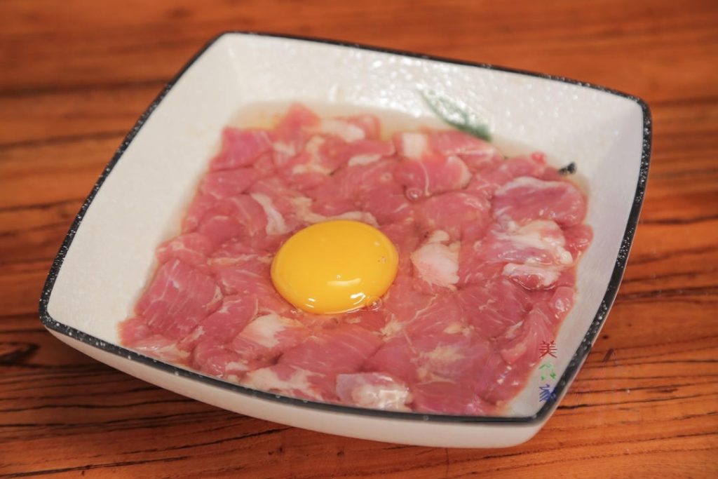 Crack 1 egg into the marinated pork and mix well until every piece is coated in egg wash.