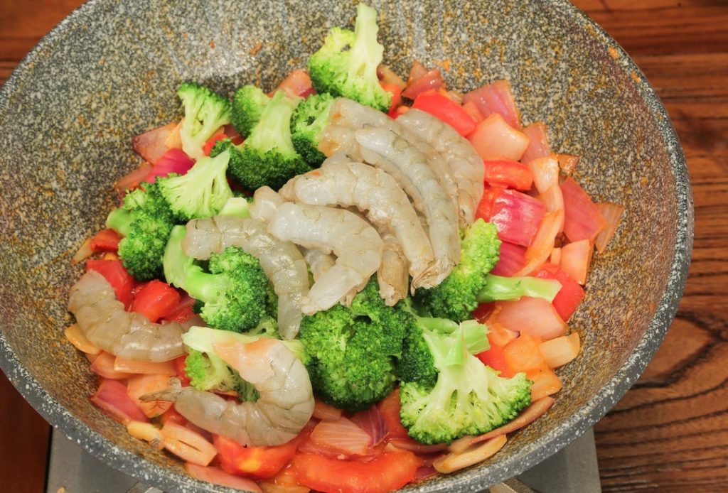 Combine and Braise Add the shrimp meat and the blanched broccoli to the pan. Stir to coat them in the tomato mixture. Pour in enough water to sit just level with the ingredients (do not drown them). Bring to a boil.