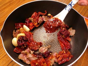Add 2 tablespoons of Doubanjiang. Stir-fry continuously for about 30 seconds until the oil turns red and the sauce smells fragrant.