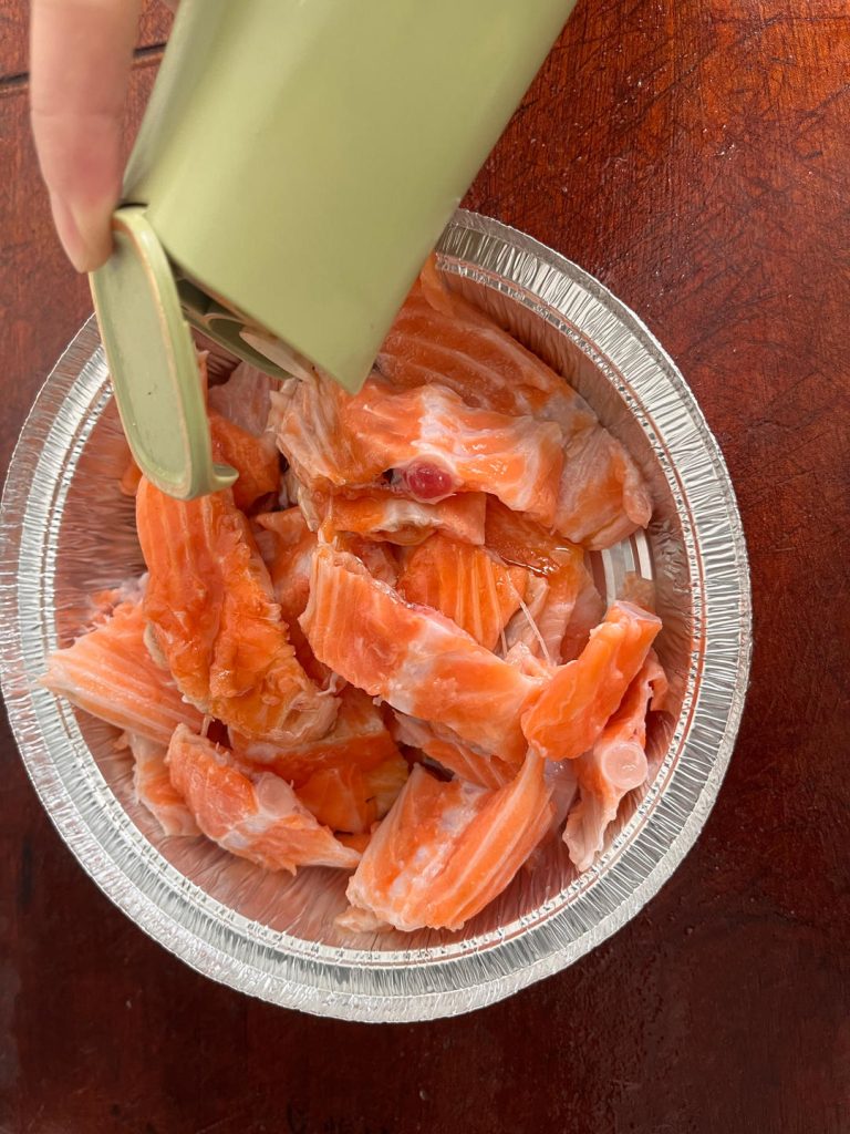 Marinate Place the salmon segments in a foil tray (or a bowl). Add 2 tablespoons of Light Soy Sauce, 1 tablespoon of Shaoxing Wine, 1/2 teaspoon of Salt, and a generous grinding of black pepper. Toss well to coat. Let this sit for 15 minutes. This allows the salt to penetrate the meat and creates a brine effect.