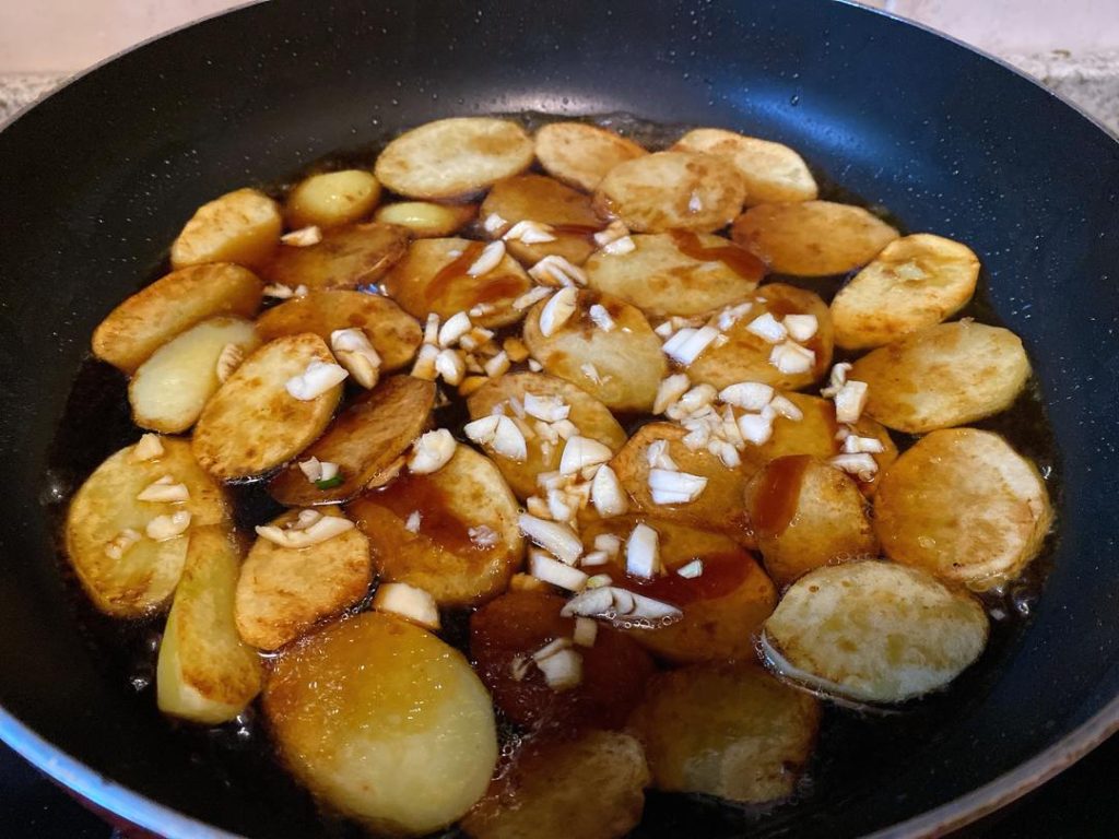 Braise (3–5 minutes): Add half a small bowl (about 1/4 cup or 60 ml) of water to the pan. Turn the heat to medium-low and let it simmer until the water dries up and the sauce clings to the potatoes. Note: If your potatoes were cut too thickly and aren't fully soft yet, add a splash more boiling water and continue simmering.