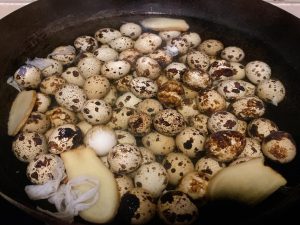 Place the rinsed quail eggs into your pot. Add the ginger slices, Shaoxing wine, and enough cold water to submerge the eggs completely. Turn the heat to your stove's lowest setting.