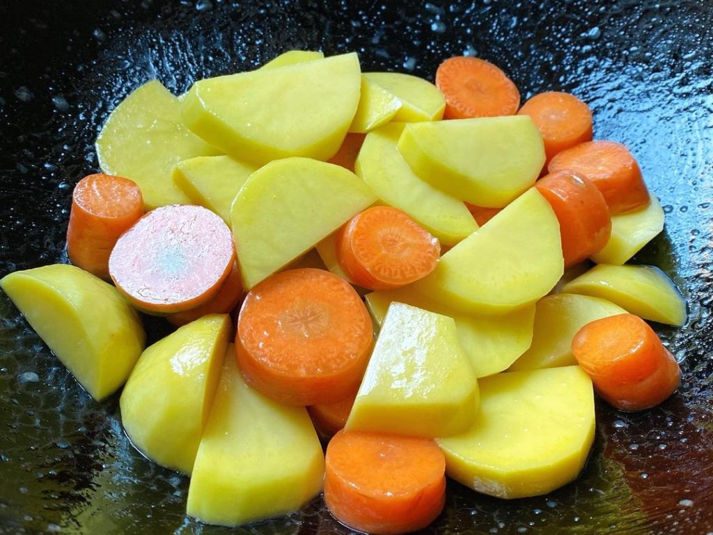 Prepare the Roasting Pan: Preheat your oven to 220°C (430°F) for 10 minutes. Line your roasting pan with aluminum foil. Toss the thick slices of potato and carrot with a little oil, salt, and pepper. Spread them out evenly on the foil, making sure there are no large gaps.