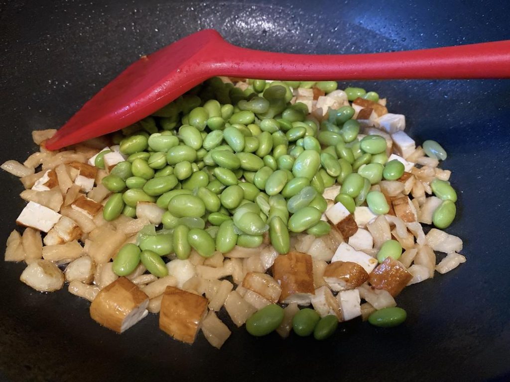 Combine the Ingredients (1 minute): Toss in the boiled soybeans and stir well. Next, return the cooked pork to the wok. We add the pork at the end because it is already cooked; exposing it to prolonged wok heat will make it tough.