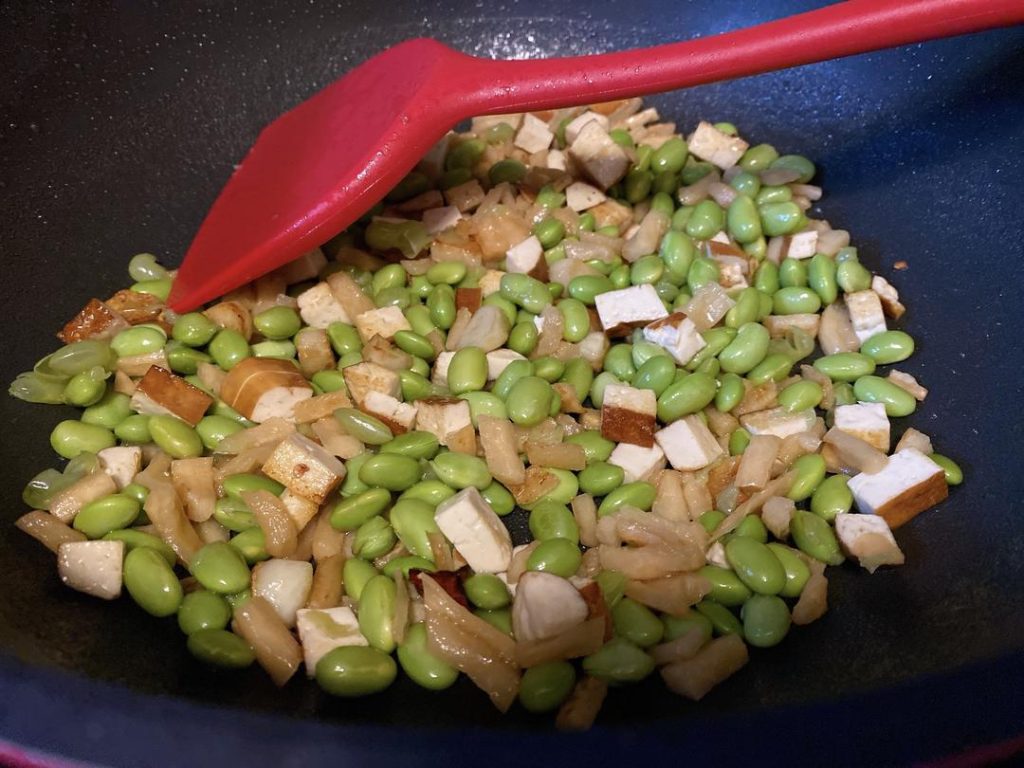 Combine the Ingredients (1 minute): Toss in the boiled soybeans and stir well. Next, return the cooked pork to the wok. We add the pork at the end because it is already cooked; exposing it to prolonged wok heat will make it tough.