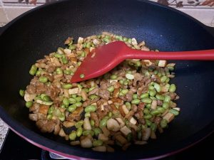 Combine the Ingredients (1 minute): Toss in the boiled soybeans and stir well. Next, return the cooked pork to the wok. We add the pork at the end because it is already cooked; exposing it to prolonged wok heat will make it tough.