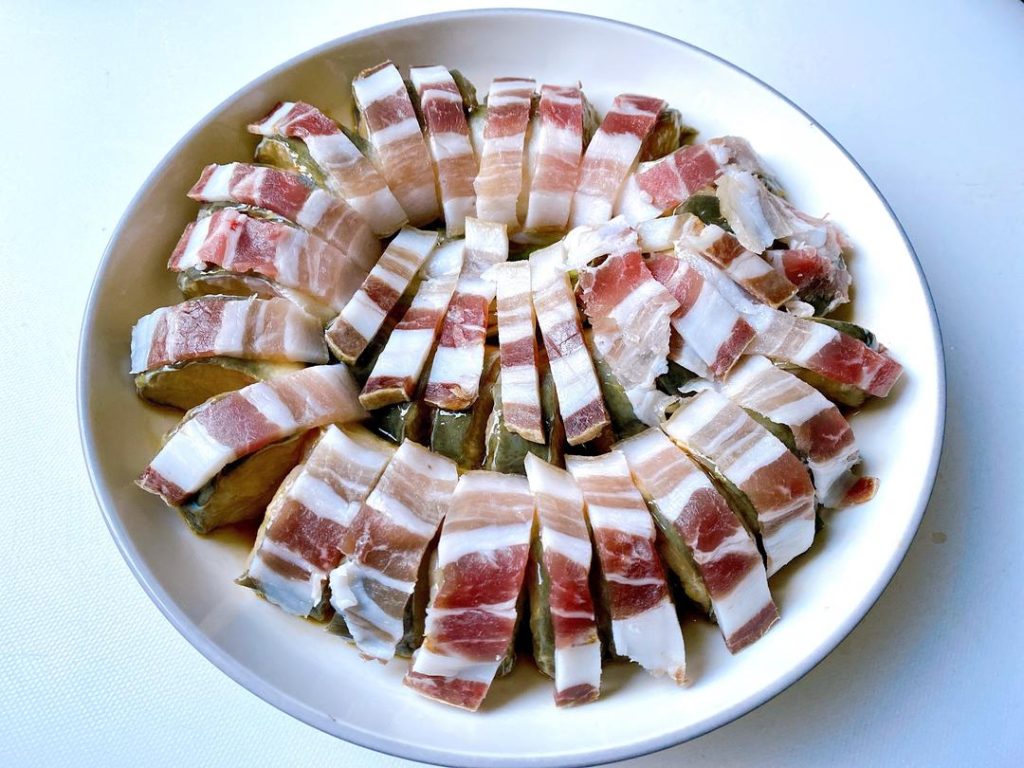 Assemble (5-10 minutes): Carefully tuck one thin slice of salted pork into each cut you made in the eel. Lay any remaining pork slices on top.