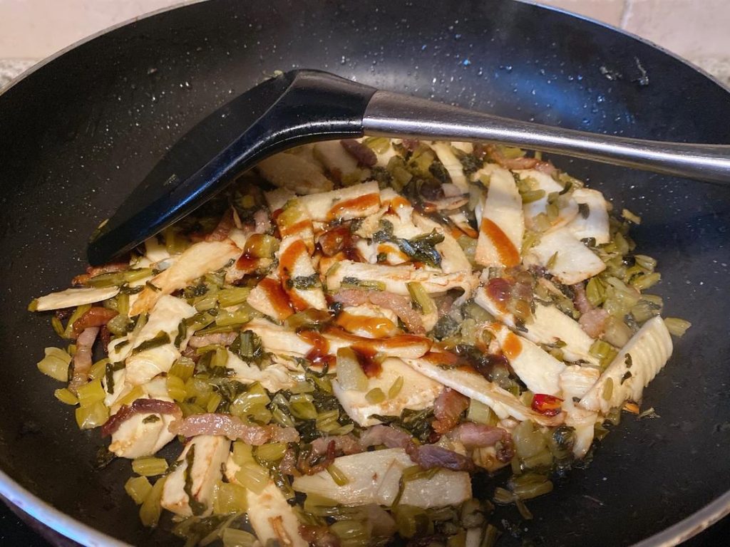 Season and Braise (3–4 minutes): Add the oyster sauce, sugar, and salt (taste the snow cabbage first to gauge how much salt you actually need). Pour in about 1/4 cup of water. Turn the heat up slightly to let the liquid bubble. This brief braising step allows the bamboo shoots to absorb the savory flavors of the meat and pickled greens.