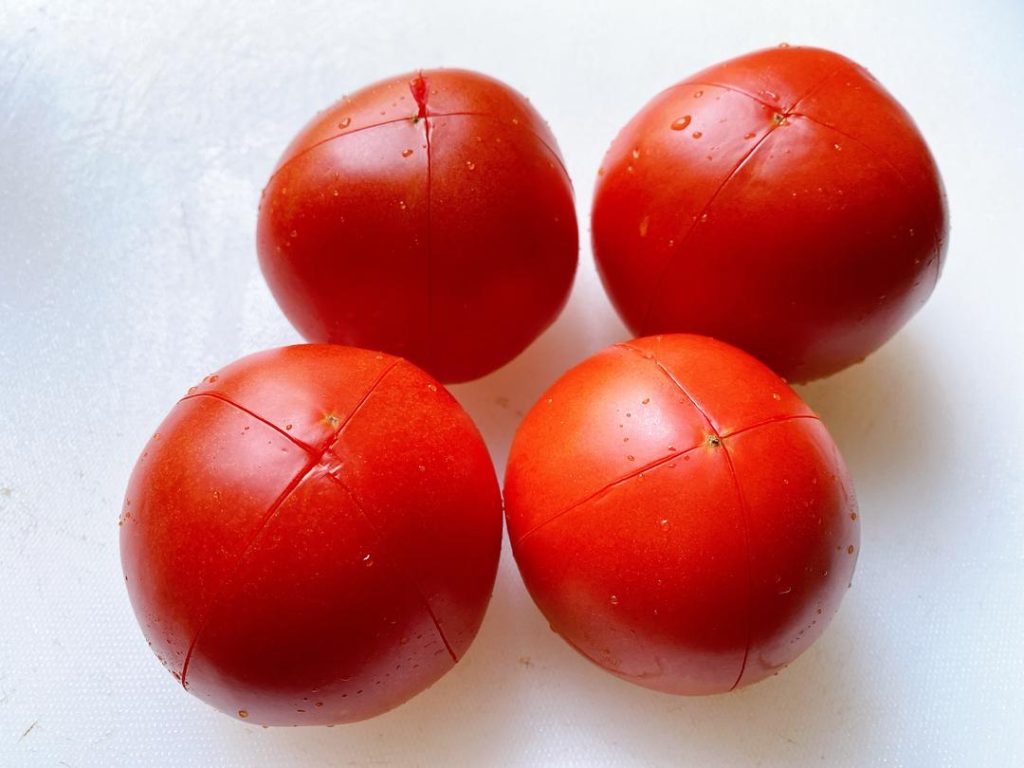Prep the Tomatoes: Score an "X" on the bottom of each tomato. Blanch in boiling water for 60 seconds, then peel off the skin. Dice the tomatoes into small cubes. Mince your ginger and garlic.