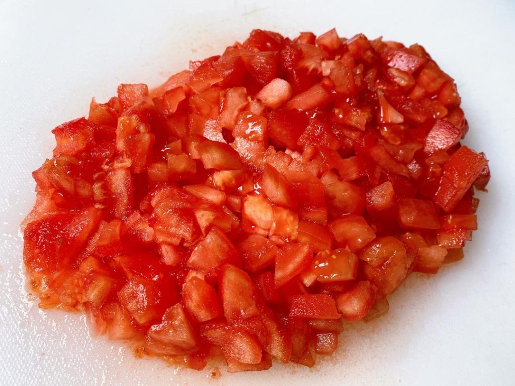 Prep the Tomatoes: Score an "X" on the bottom of each tomato. Blanch in boiling water for 60 seconds, then peel off the skin. Dice the tomatoes into small cubes. Mince your ginger and garlic.