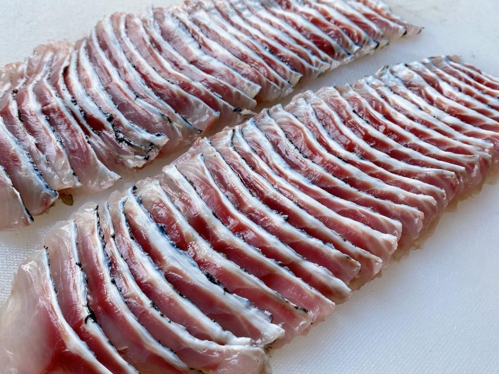 Fillet and Clean: Ask your fishmonger to fillet the fish and give you the bones, or do it yourself. Remove the ribs from the fillets and slice the meat at a 45-degree angle into 1/4-inch (6 mm) thick slices. Chop the fish bones into 2-inch chunks.