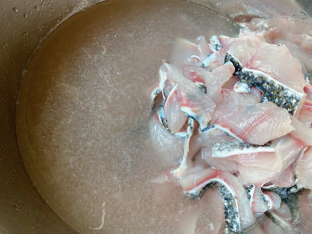 The Crucial Wash: Place the fillets and bones in two separate bowls. Add 1 tsp of salt and 2 tbsp of Shaoxing wine to each bowl. Gently massage the fish for 1-2 minutes. Rinse under cold water until the water runs completely clear.