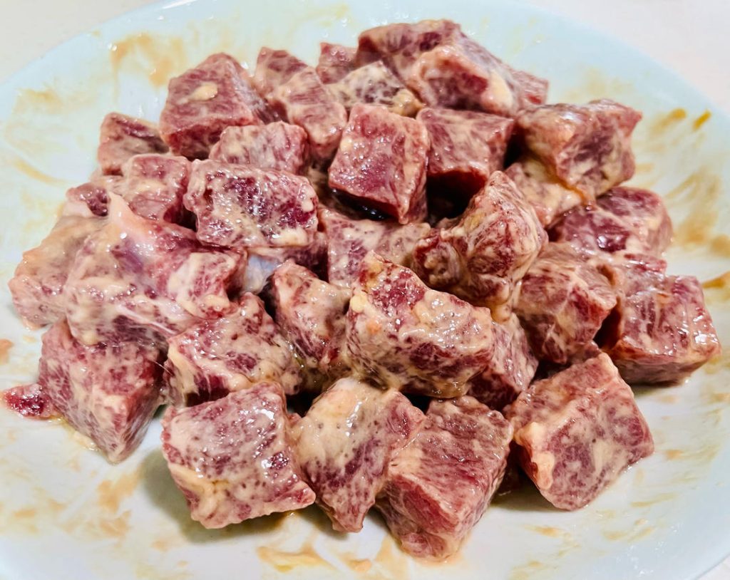 Add the oyster sauce, Shaoxing wine, a pinch of sugar, and the cornstarch. Mix vigorously in one direction until the liquid is absorbed. Finally, pour in the 2 tablespoons of olive oil to seal the marinade. Cover with plastic wrap and refrigerate for at least 25 minutes.