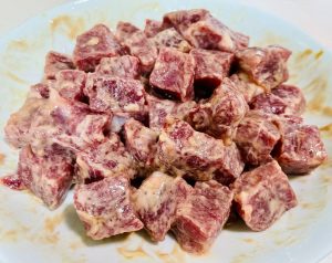 Add the oyster sauce, Shaoxing wine, a pinch of sugar, and the cornstarch. Mix vigorously in one direction until the liquid is absorbed. Finally, pour in the 2 tablespoons of olive oil to seal the marinade. Cover with plastic wrap and refrigerate for at least 25 minutes.