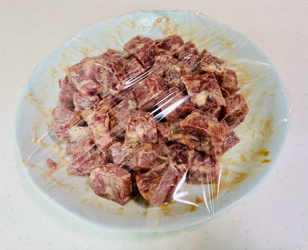 Add the oyster sauce, Shaoxing wine, a pinch of sugar, and the cornstarch. Mix vigorously in one direction until the liquid is absorbed. Finally, pour in the 2 tablespoons of olive oil to seal the marinade. Cover with plastic wrap and refrigerate for at least 25 minutes.