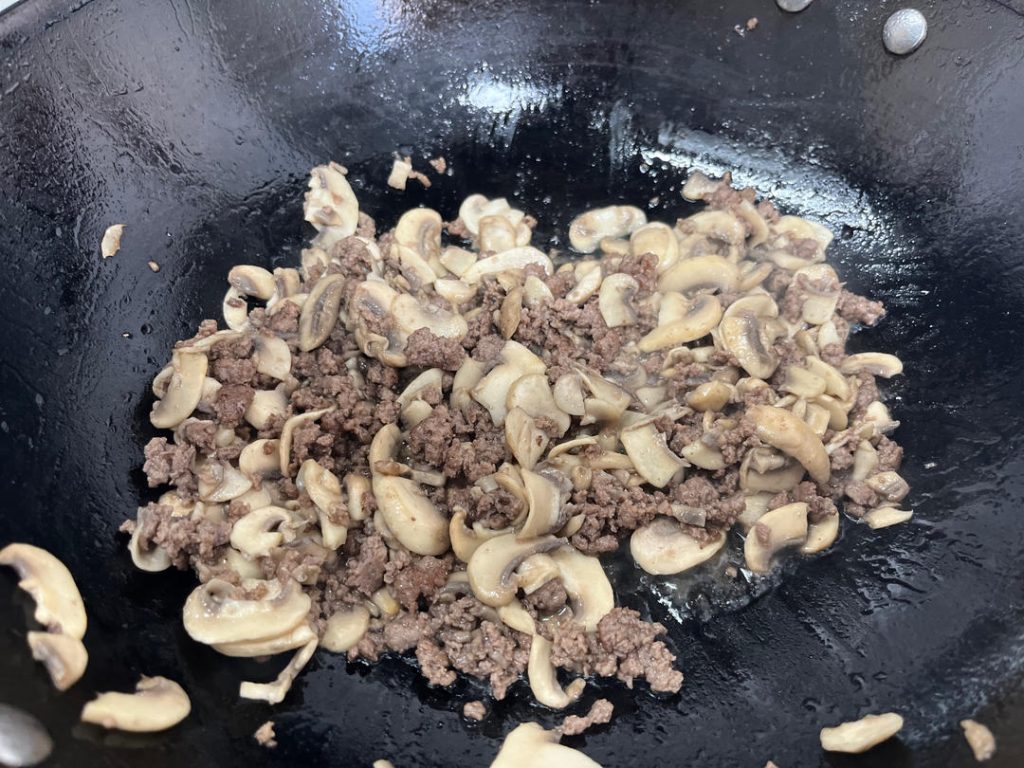 Cook Mushrooms and Remove Moisture Once the beef is browned and has released its fat, add the sliced mushrooms. Stir-fry them together. Add the Light Soy Sauce and Salt now.