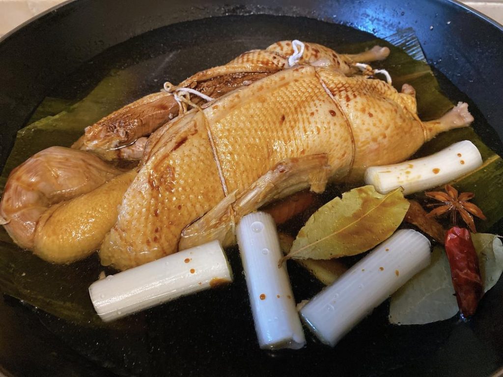 Build the Braise: Add the braising ginger, scallion, bay leaves, star anise, tangerine peel, and chilies. Pour in the light soy sauce, dark soy sauce, oyster sauce, sugar, and remaining 4 tbsp Shaoxing wine. Fill the pot with enough water to submerge the duck halfway. Do not add the salt yet.